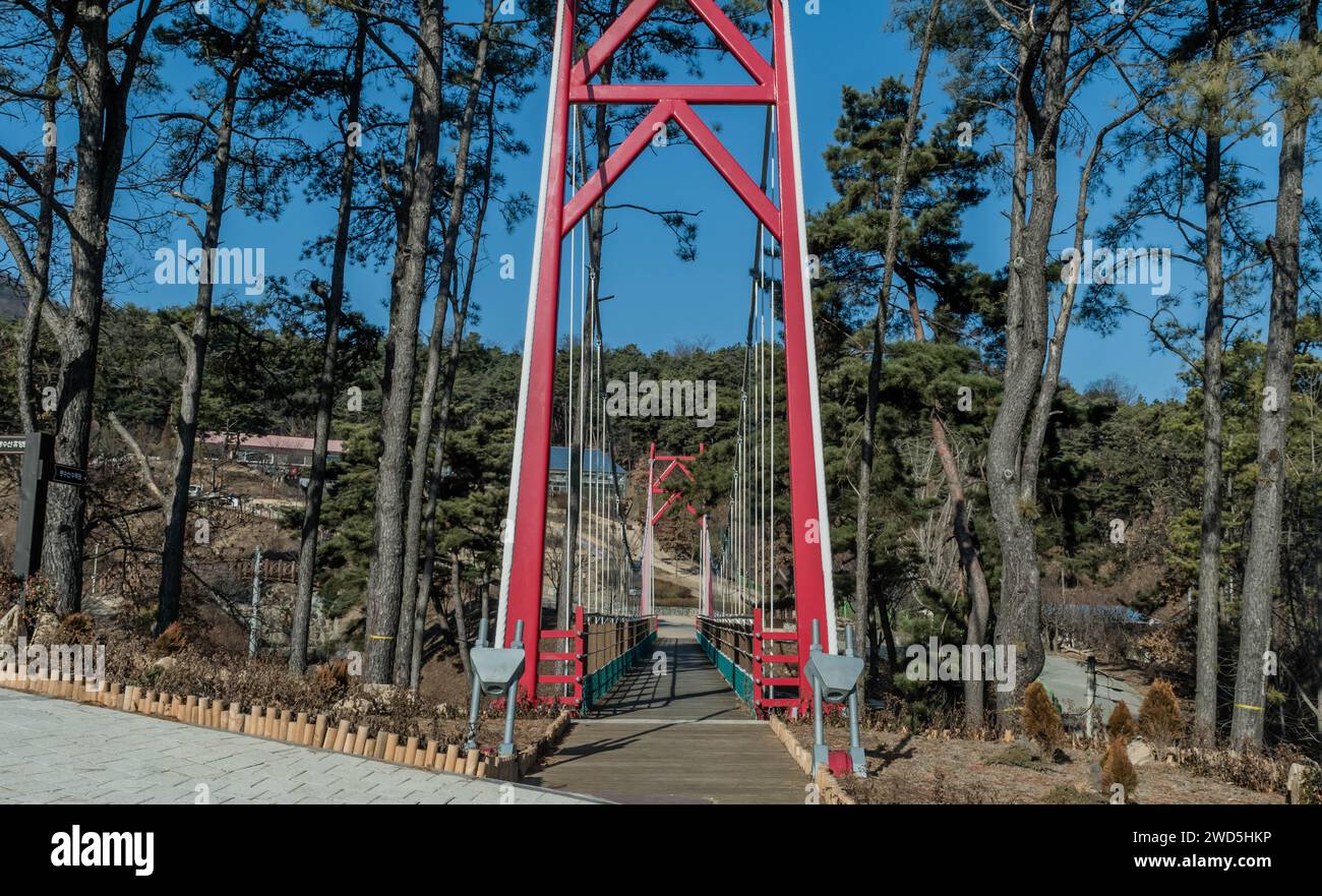 Rotes Kabel hielt Fußbrücke am Eingang zum öffentlichen Bergpark an sonnigen Tagen mit klarem blauem Himmel in Südkorea Stockfoto