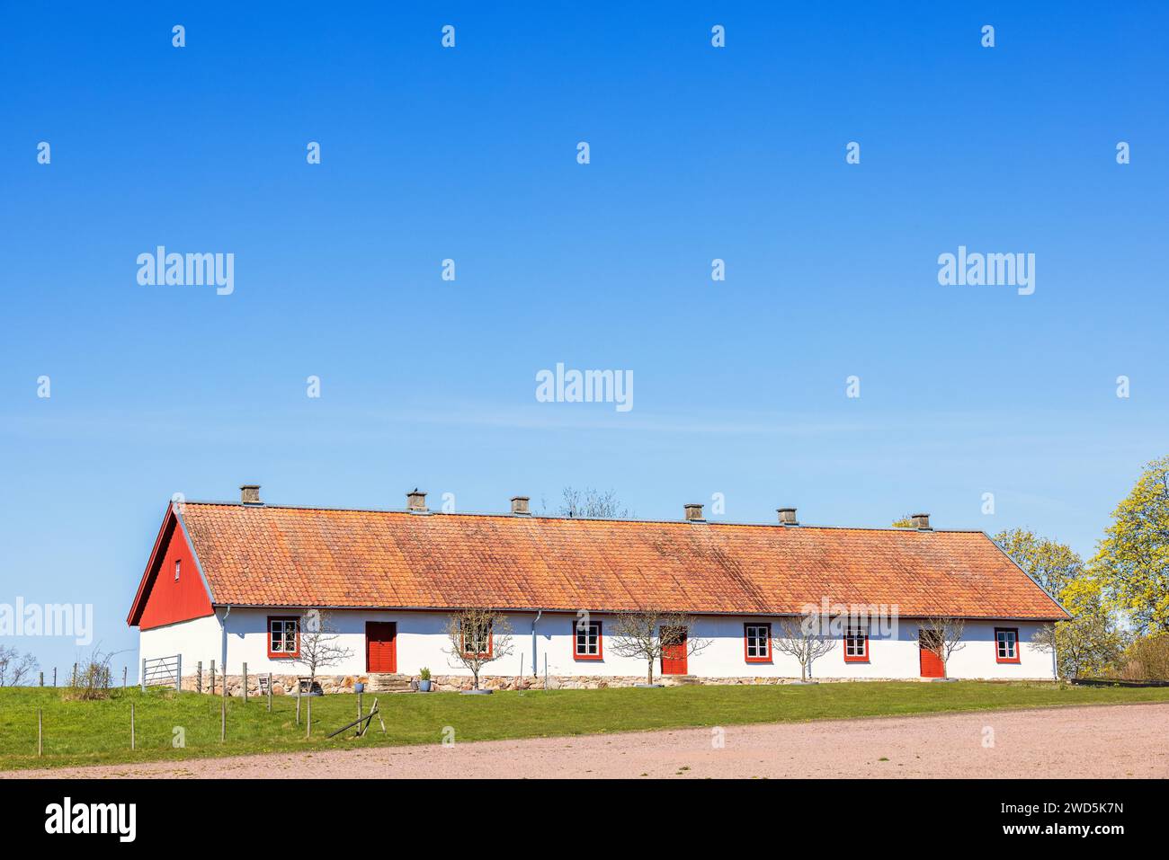 Alte Scheune, die an einem sonnigen Frühlingstag in Schweden in ein Wohngebäude umgewandelt wurde Stockfoto