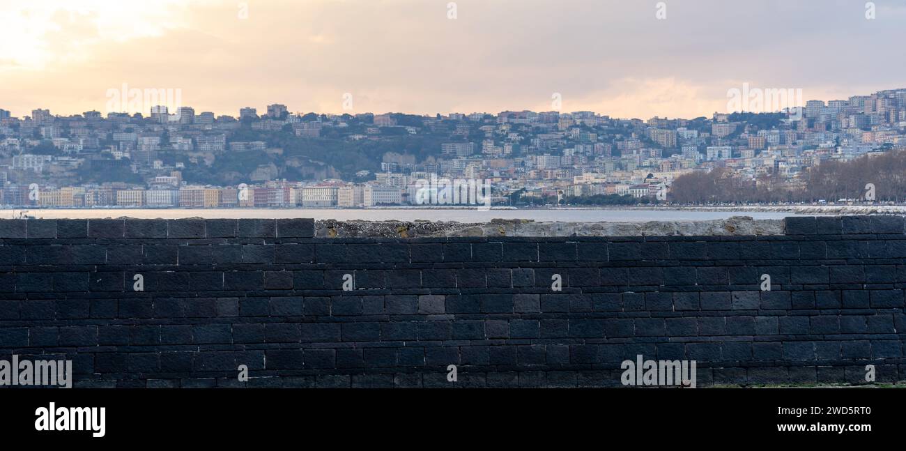 Schwarze Mauer mit Stadt im Hintergrund über das Tyrrhenische Meer von der Eierburg. Neapel, Italien Stockfoto