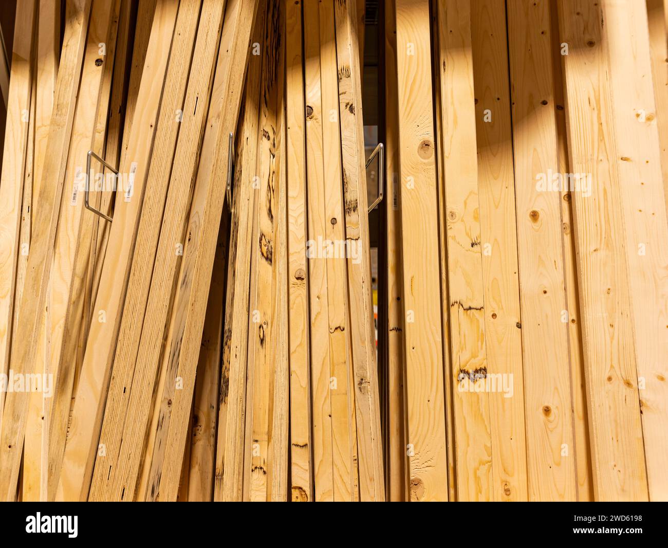 Holzdielen in einem Eisenwarenladen. Die Holzbretter werden in vertikaler Richtung in einem Regal gelagert. Baumaterial in einem Geschäft zur Heimverbesserung Stockfoto