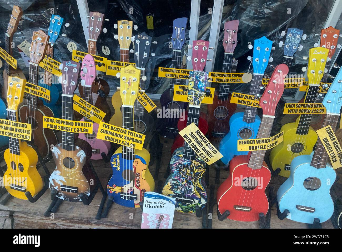 Ein Schaufenster mit Musikinstrumenten, in dem viele Ukulele zum Verkauf stehen. Stockfoto