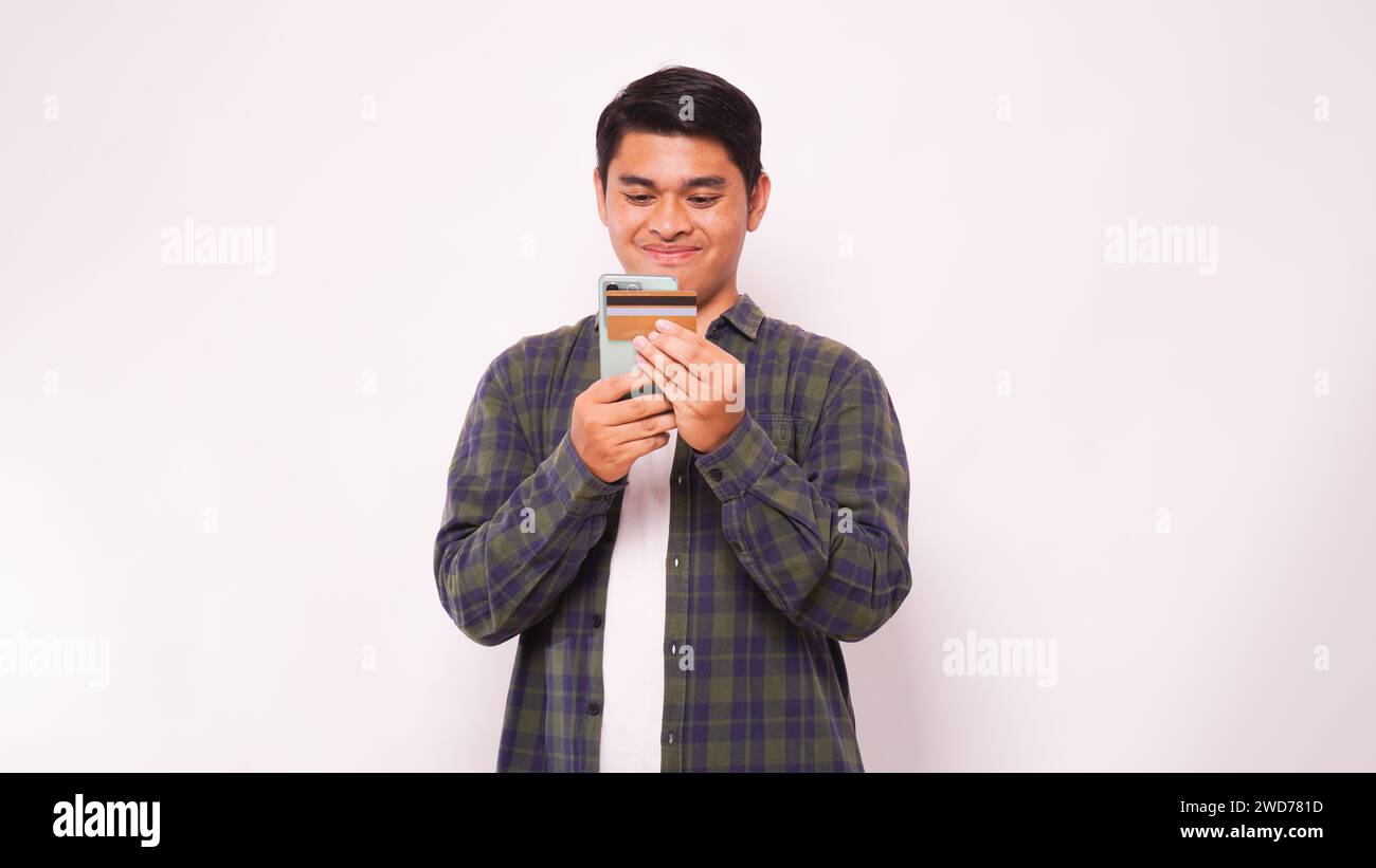 Asiatischer Mann, der Smartphone hält, mit der Verarbeitung mobiler Zahlungen von Kreditkarte über weißem Hintergrund Stockfoto