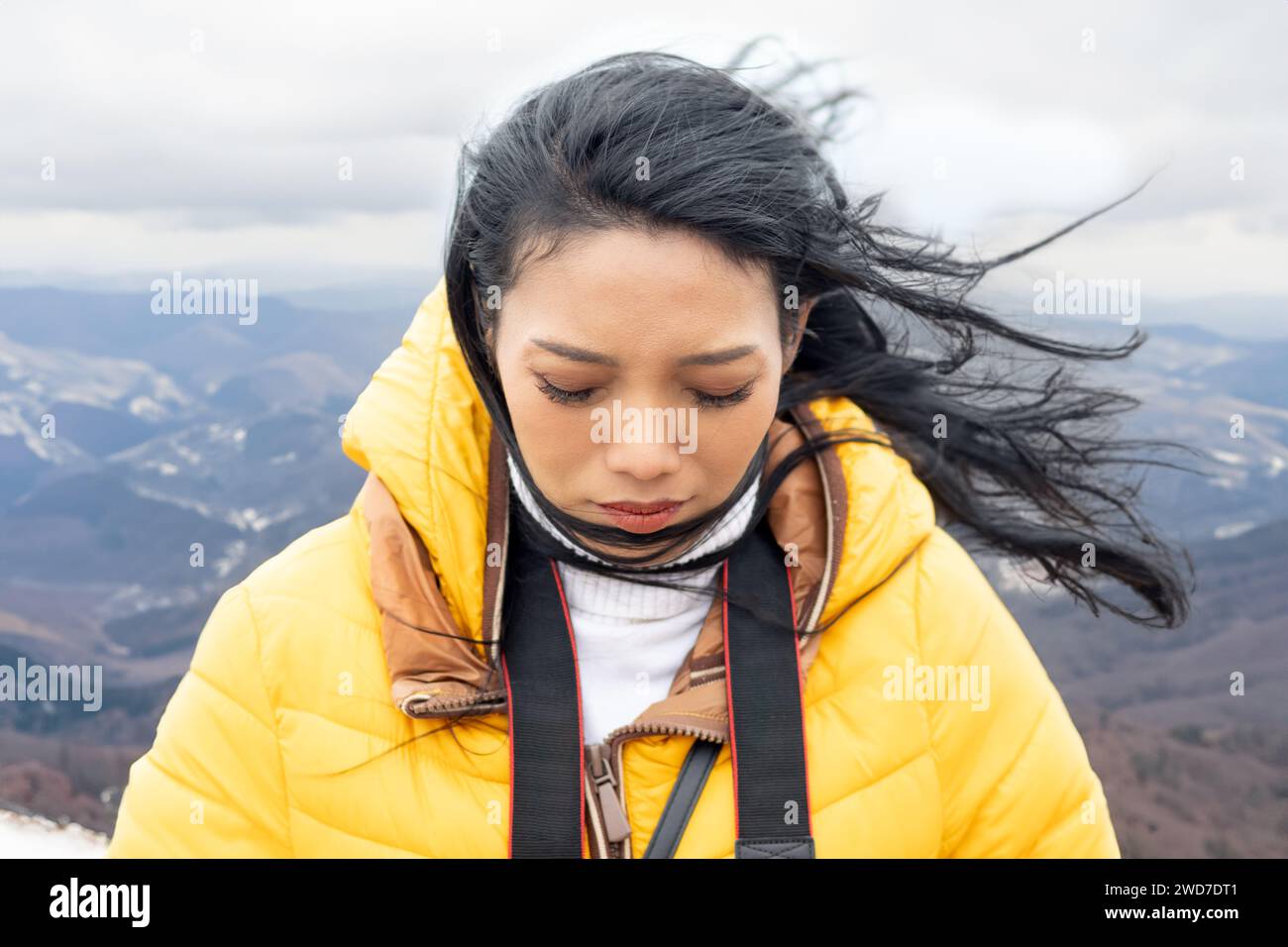 Eine junge Frau auf dem windigen Berg Stockfoto