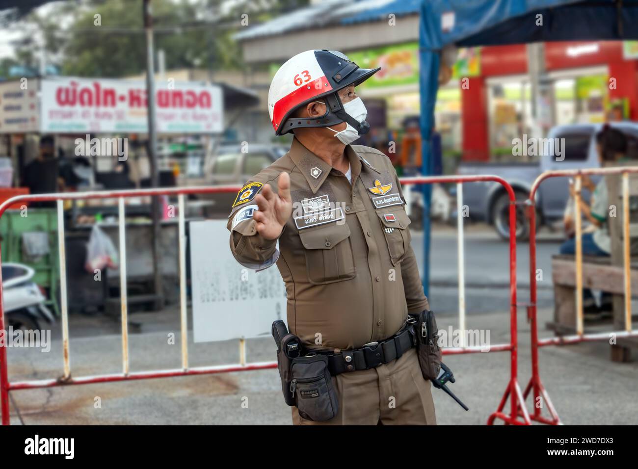 SAMUT PRAKAN, THAILAND, 11. November 2023, Ein Verkehrspolizist lenkt den Verkehr in der Abenddämmerung auf die Straße Stockfoto