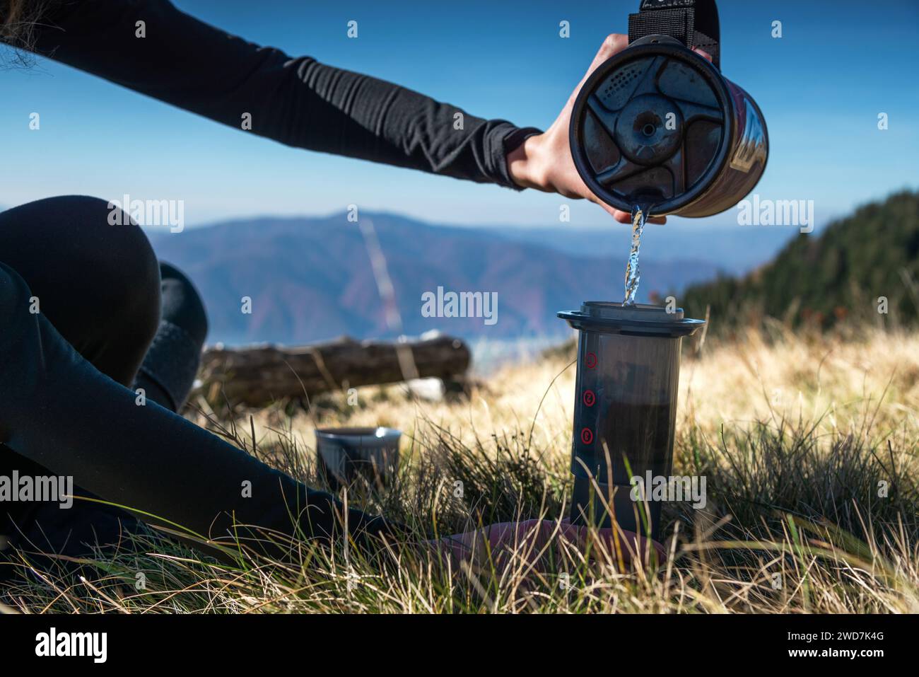 Close Up Female Hands bereitet Kaffee mit einer AeroPress in den Bergen zu Stockfoto