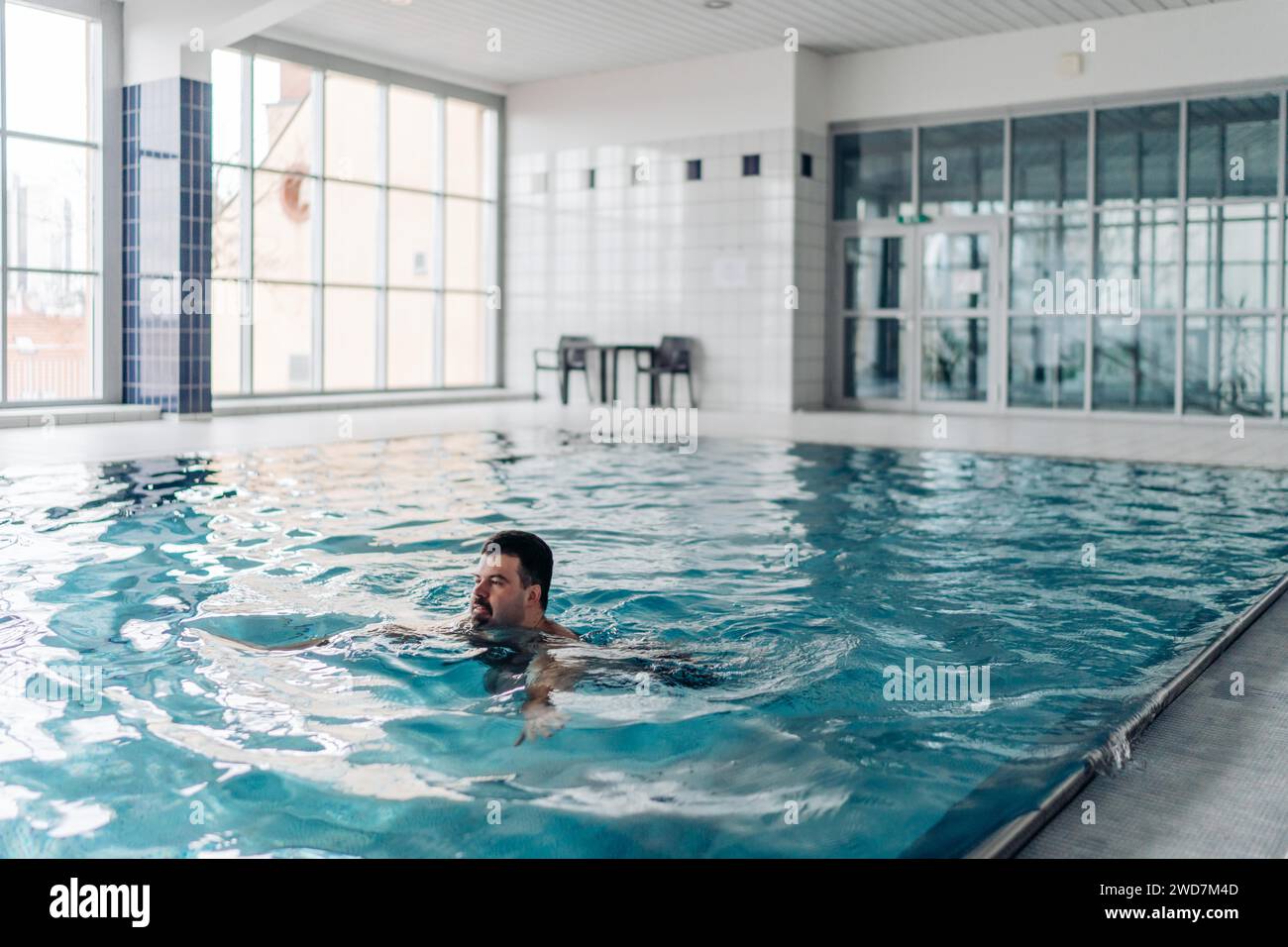 Ein 40-jähriger Mann schwimmt in einem Pool mit Blick auf Prag Stockfoto