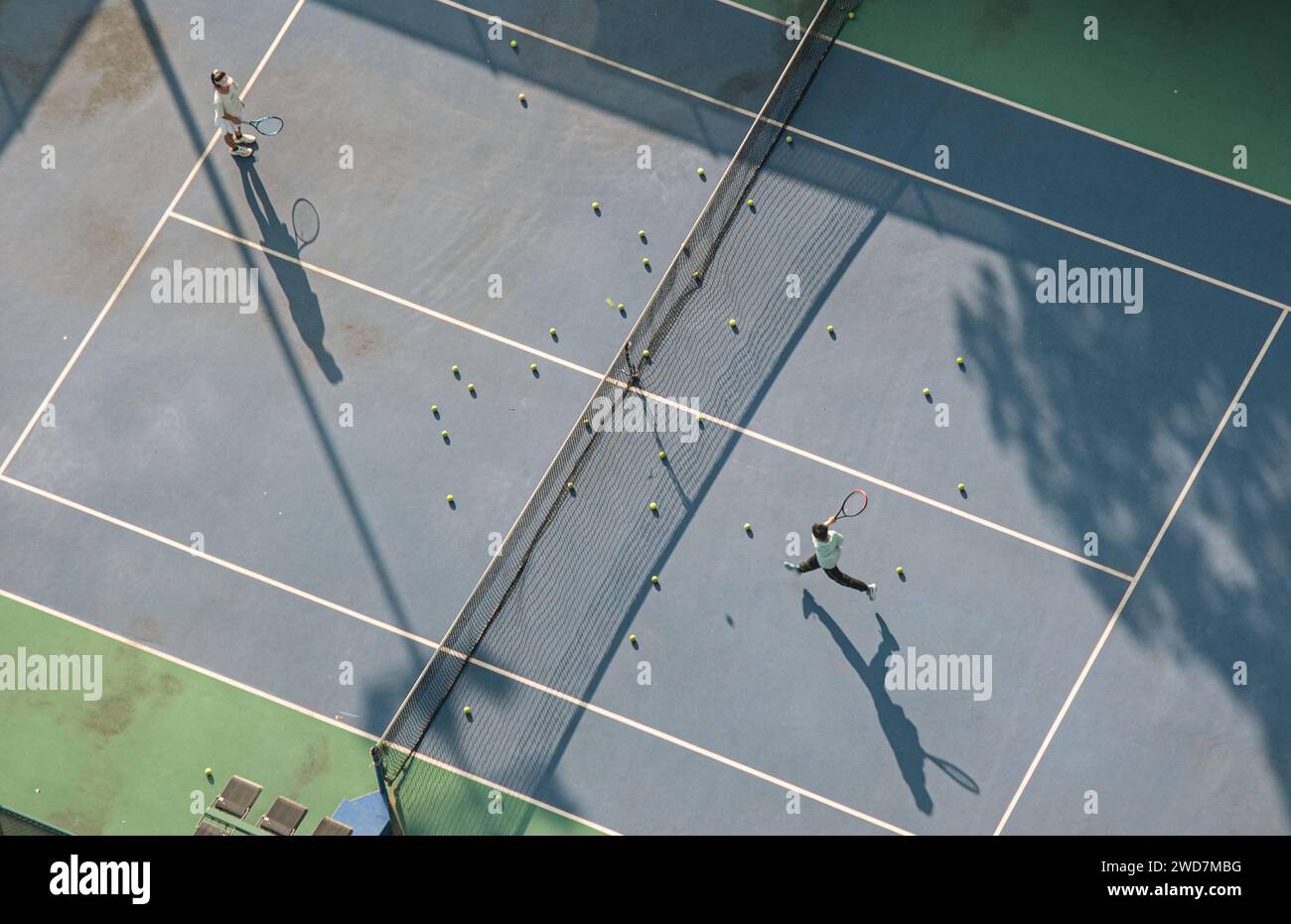 Die beiden Tennisspieler spielen auf einem unbewohnten Tennisplatz ein freundliches Doppel-Spiel Stockfoto