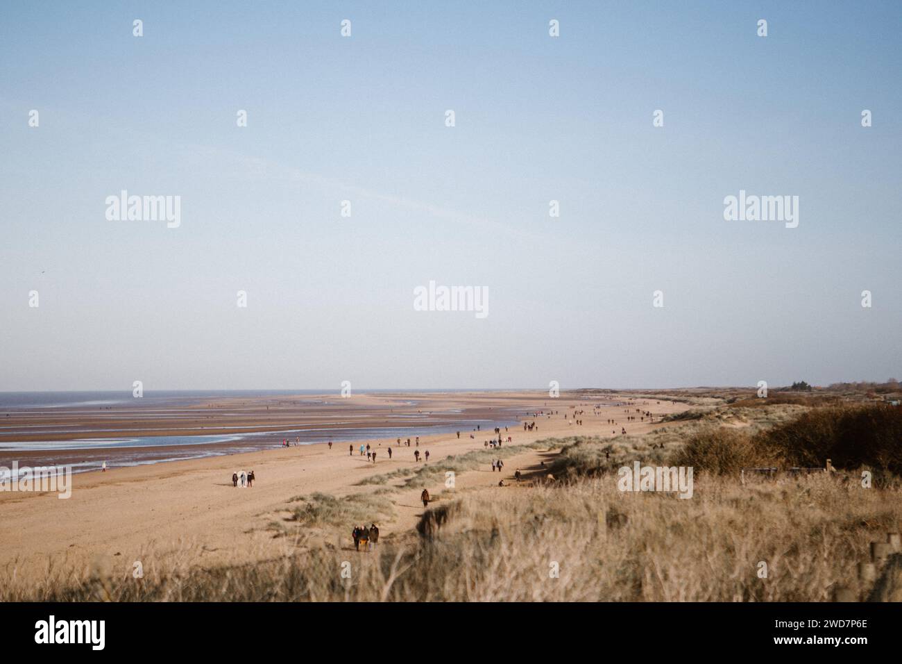 Strandwanderer in Hunstanton an einem sonnigen Wintertag Stockfoto