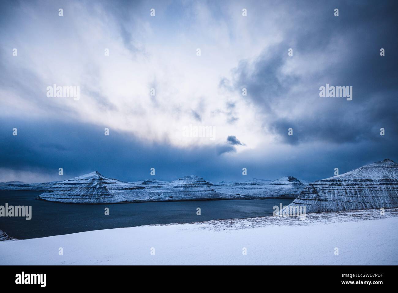 Schneebedeckte Landschaft mit Blick auf die wunderschönen Fjorde der Färöer Inseln Stockfoto