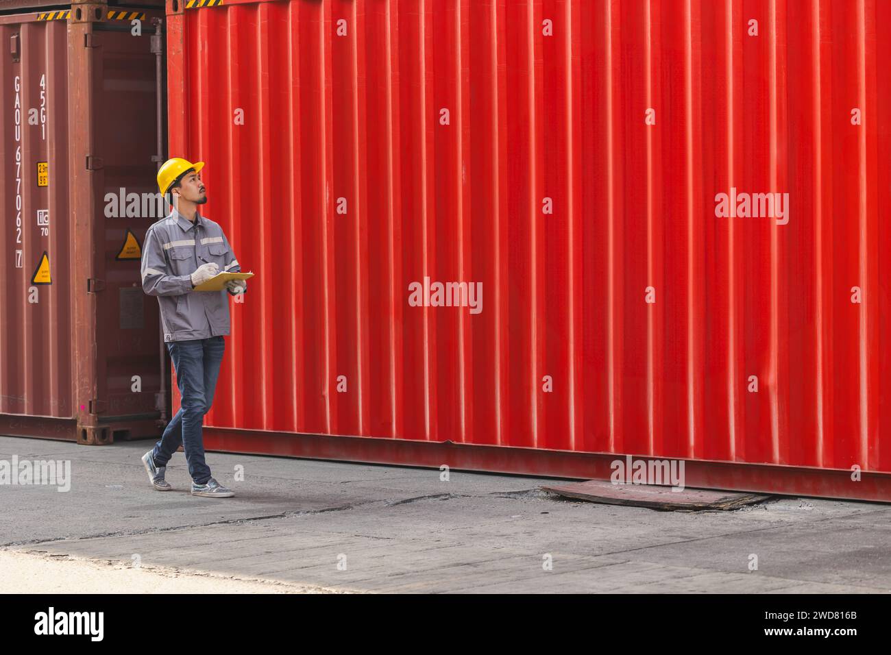 Japanischer, intelligenter Arbeiter, der in der Containerladung arbeitet. Zollpersonal der japanischen Versandlogistik. Stockfoto