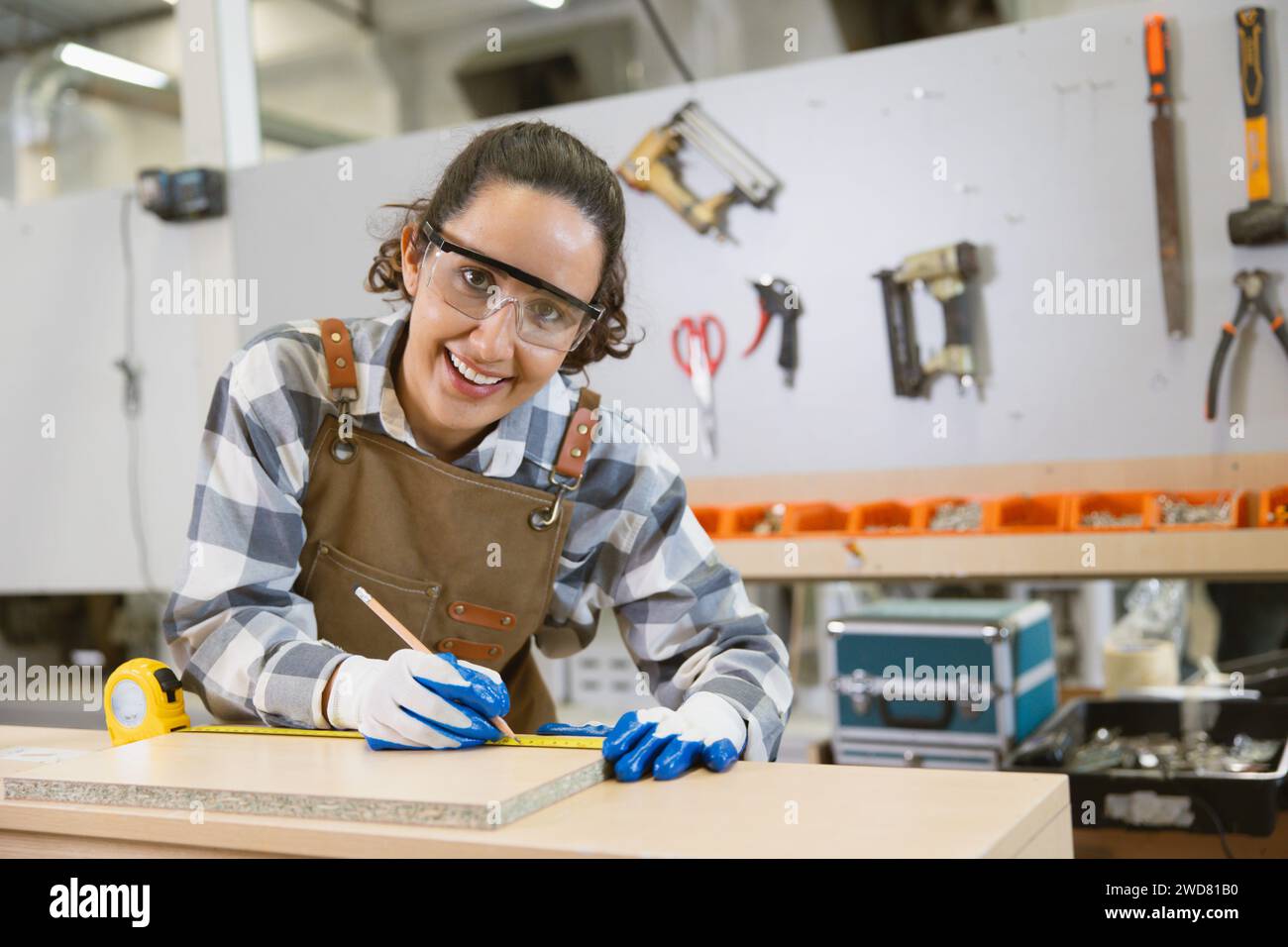 Glückliche Frauen arbeiten gerne als Designer in der Holzwerkstatt. Schreiner Holzschürze Arbeiter Möbel handgefertigte Fabrik. Stockfoto