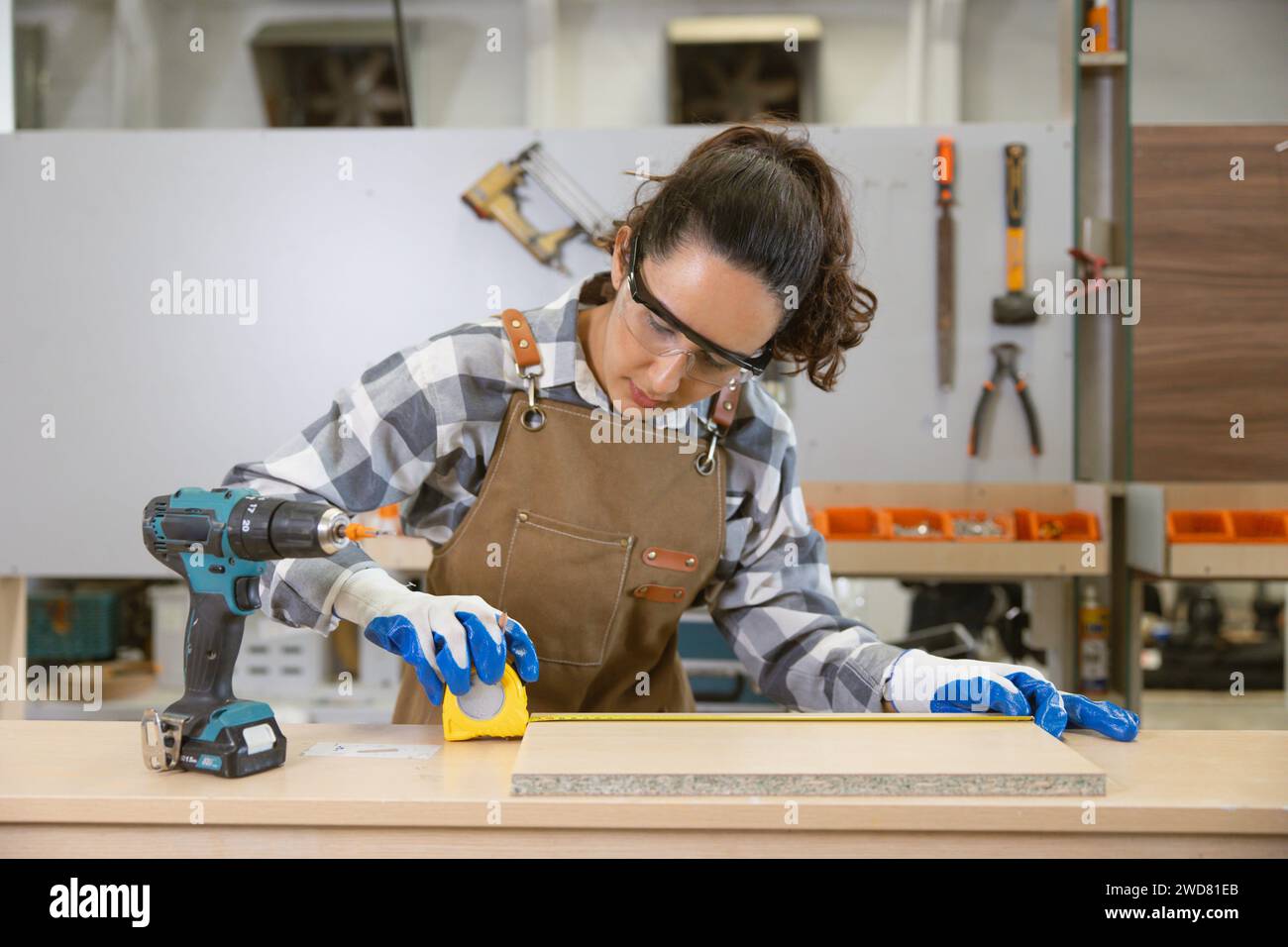 Glückliche Frauen arbeiten gerne als Designer in der Holzwerkstatt. Schreiner Holzschürze Arbeiter Möbel handgefertigte Fabrik. Stockfoto