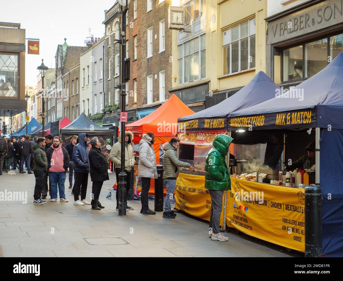 Leute stehen an den Imbissständen auf dem Berwick Street Market in Soho, London, Großbritannien Stockfoto