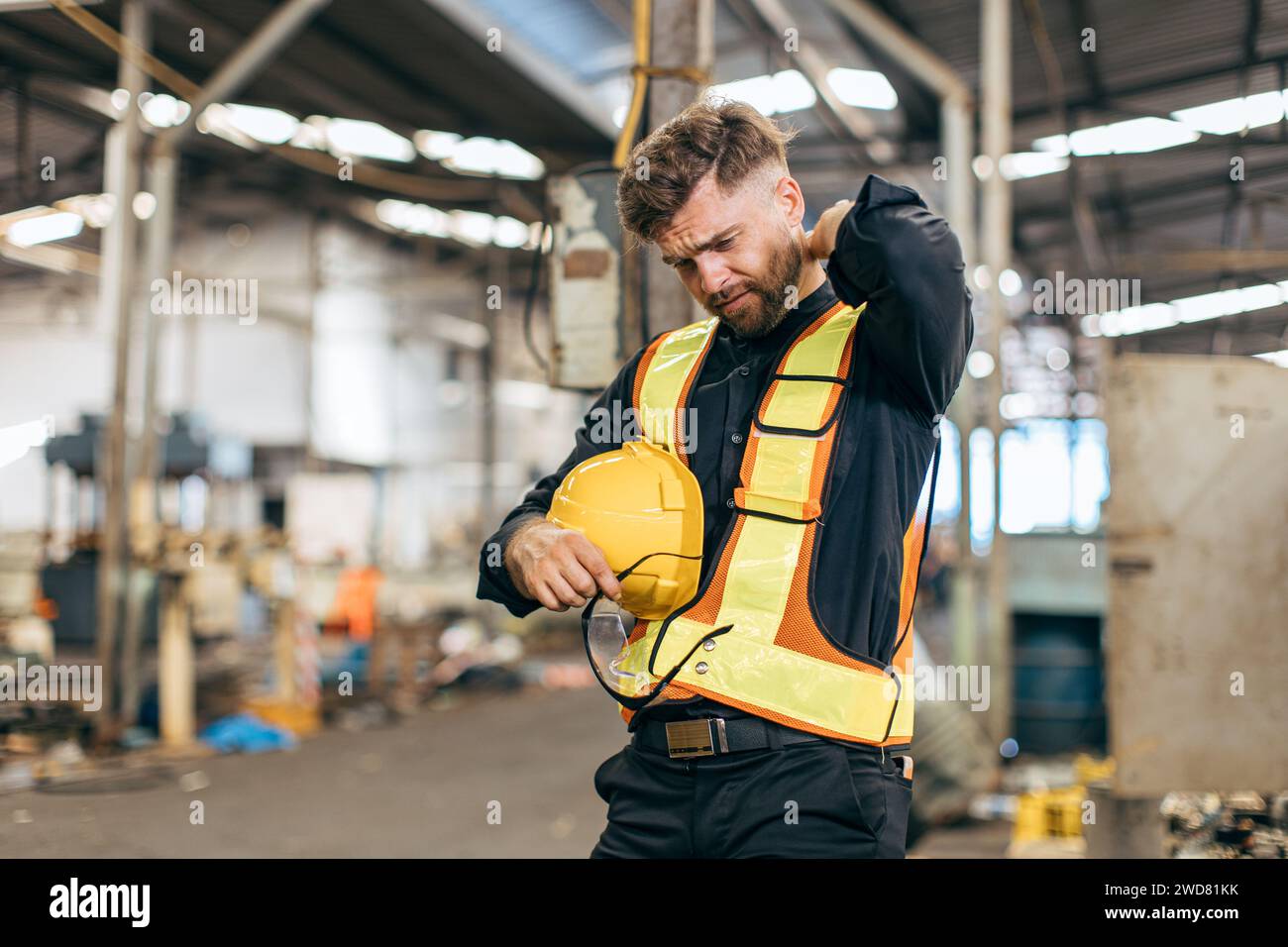 Müde Ermüdung Muskelschmerzen Ingenieur harte Arbeit männliches Personal in schweren Indsutry Fabrik Stockfoto