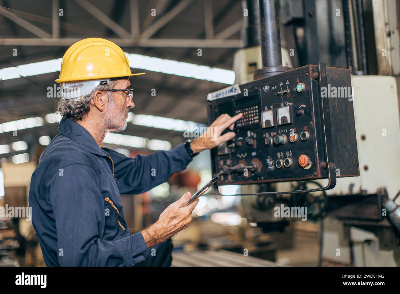 Leitende professionelle Ingenieur Arbeitssteuerung betreiben Programm CNC-Fräsmaschine in der Schwerindustriefabrik Stockfoto