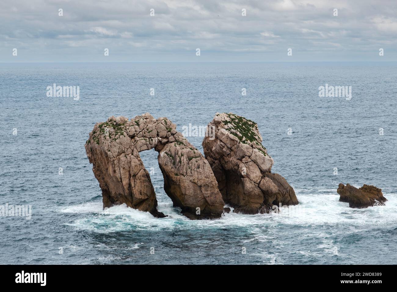 Urro del Manzano (auch bekannt als Canto del Diablo oder La Puerta), natürliche Bogenbrücke, die von der Wellenbewegung des Kantabrischen Meeres geschnitzt wurde. Urros de Liencres Stockfoto
