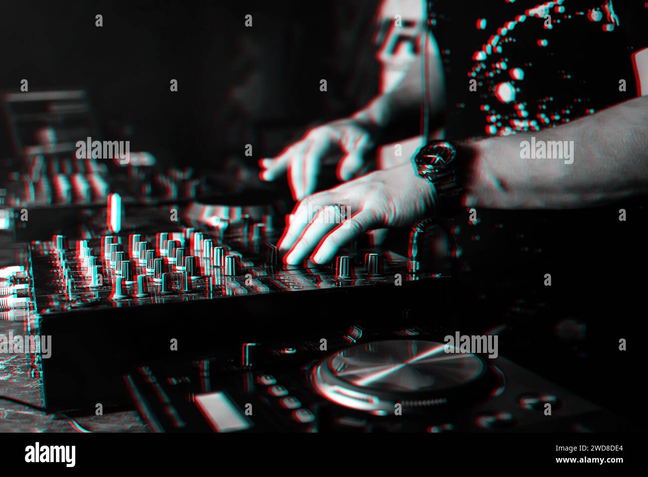DJ mischt Musik auf professionellen Musiktafeln und Ausrüstung zum Mixen von Musik im Nachtclub. Schwarzweißfoto mit Glitcheffekt und geringer Körnung Stockfoto