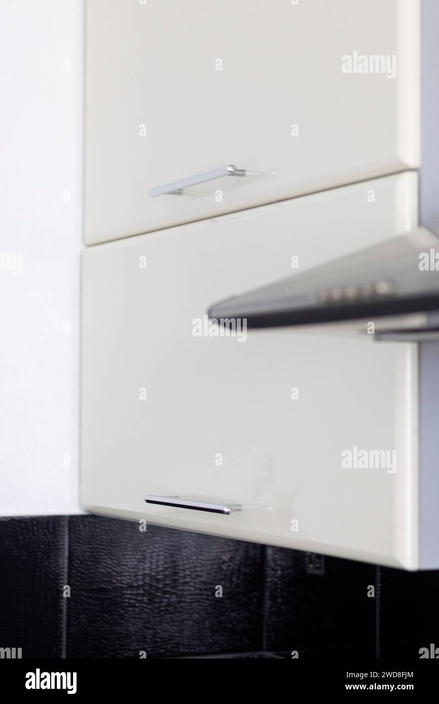 Nahaufnahme der Küchenschränke und des elektrischen Abluftsystems in der Küche Stockfoto