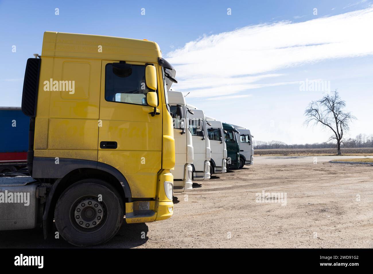Mehrere Lkw parkten an einem sonnigen Tag hintereinander Stockfoto