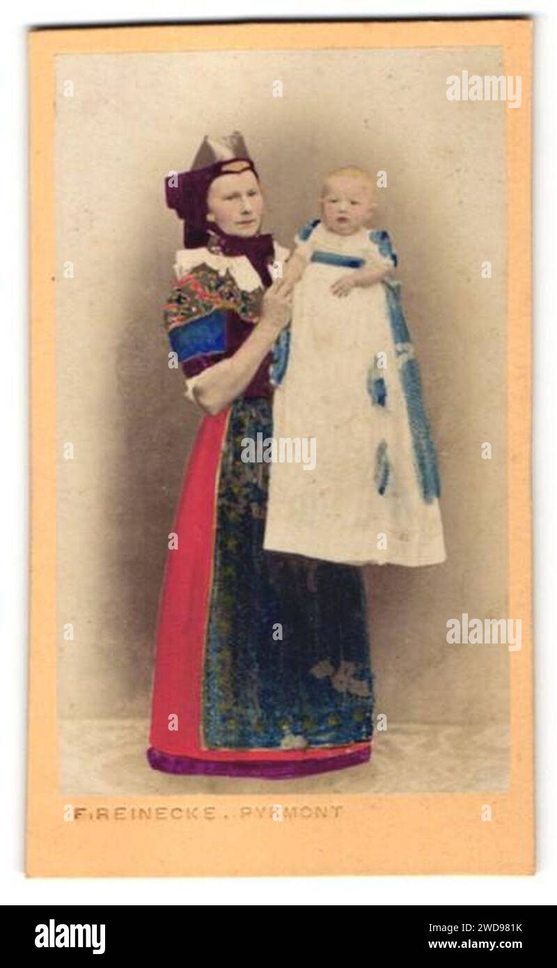 1870er Jahre circa Friedrich Reinecke kolorierte Fotografie Frau in Tracht mit ihrem Kinde in Bad Pyrmont, Bildseite. Stockfoto