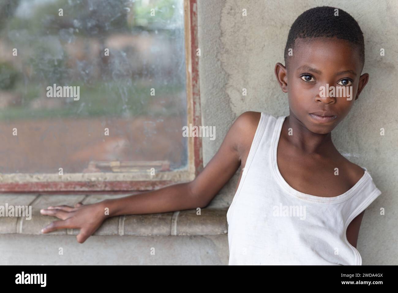afrikanisches Kind hängt vor dem Haus und wartet auf ihre Mutter Stockfoto