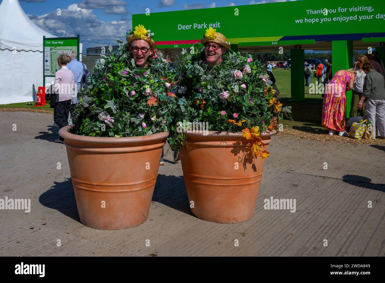 Flowerpot-Männer in lustigen Outfits (Entertainer, die Spaß haben, glücklich lächelnde Gesichter) - RHS Flower Show Tatton Park 2023, Cheshire England, Großbritannien. Stockfoto