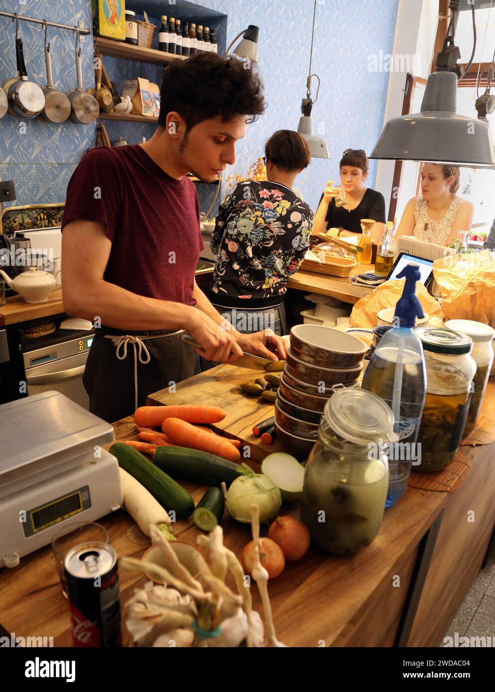 Krakau. Krakau. Polen. Junger Mann, der in der offenen Küche des Restaurants Gemüse hackt. Stockfoto