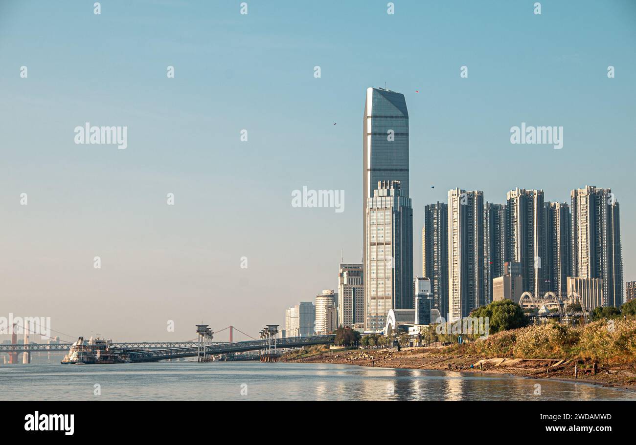 Die Skyline von Wuhan mit modernen Wolkenkratzern, elegant am riesigen Yangtze-Fluss gelegen, mit Brücken und Docks an der nahe gelegenen Flussoberfläche. Stockfoto