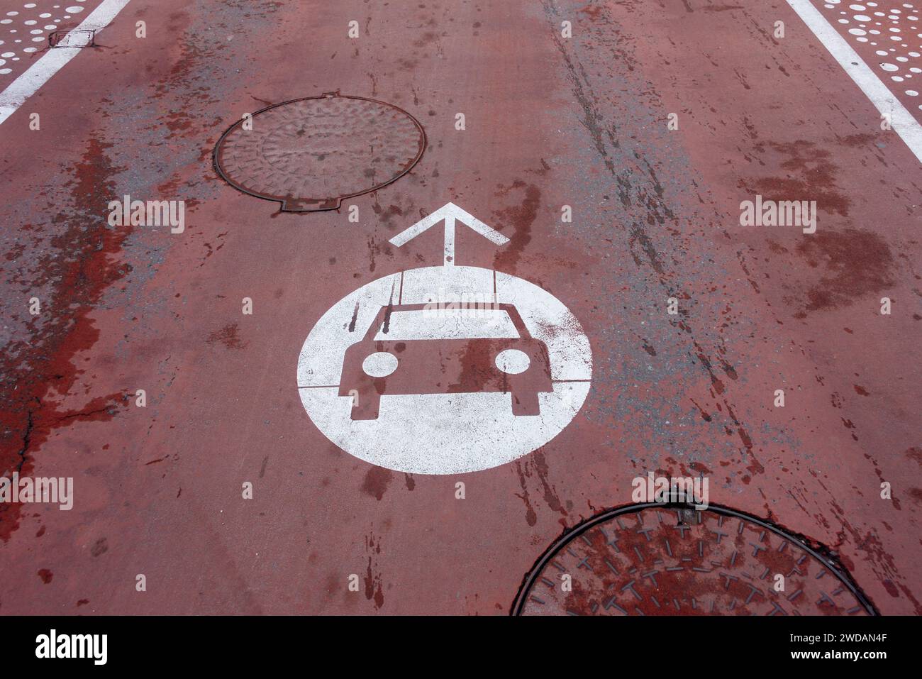 Rote Straße mit einem Auto-Symbol auf der Oberfläche Stockfoto
