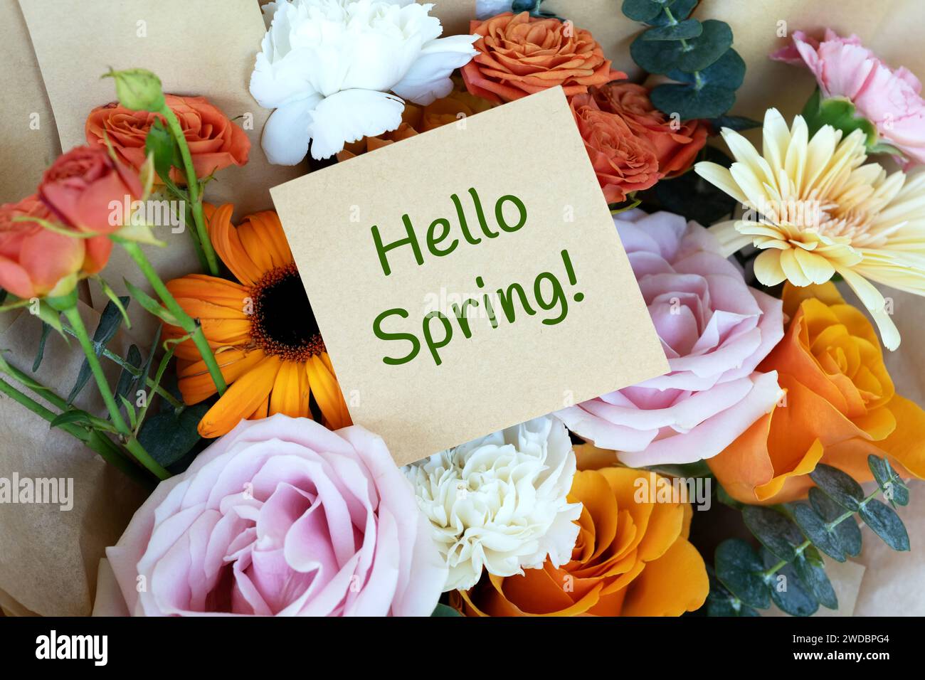 Hallo Frühlingstext auf Haftnotiz und Blumenstrauß Stockfoto