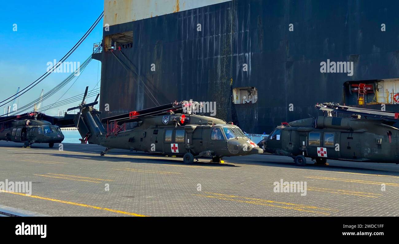 UH-60 Black Hawk Utility taktische Transporthubschrauber, die der 82. Airborne Combat Aviation Brigade zugeteilt sind, werden in der Nähe des Green Cove Frachtschiffs an einem nicht offengelegten Ort im Central Command Area of Operations der US Army, 8. Dezember 2023, inszeniert. nach einem globalen Transport, der durch das Surface Deployment Distribution Command und Mitglieder der US-amerikanischen Handelsmarines erleichtert wurde. Der Hafenbetrieb ist von entscheidender Bedeutung, um einen nahtlosen logistischen Einsatz für eine nachhaltige Projektion der Kampftruppe zu gewährleisten. Diese Luftverkehrsmittel werden es den Soldaten ermöglichen, Truppen in der gesamten Region rasch zu unterstützen Stockfoto