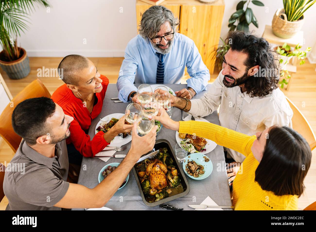 Draufsicht auf eine generationsübergreifende Gruppe von Menschen, die zu Hause zusammen zu Mittag essen Stockfoto