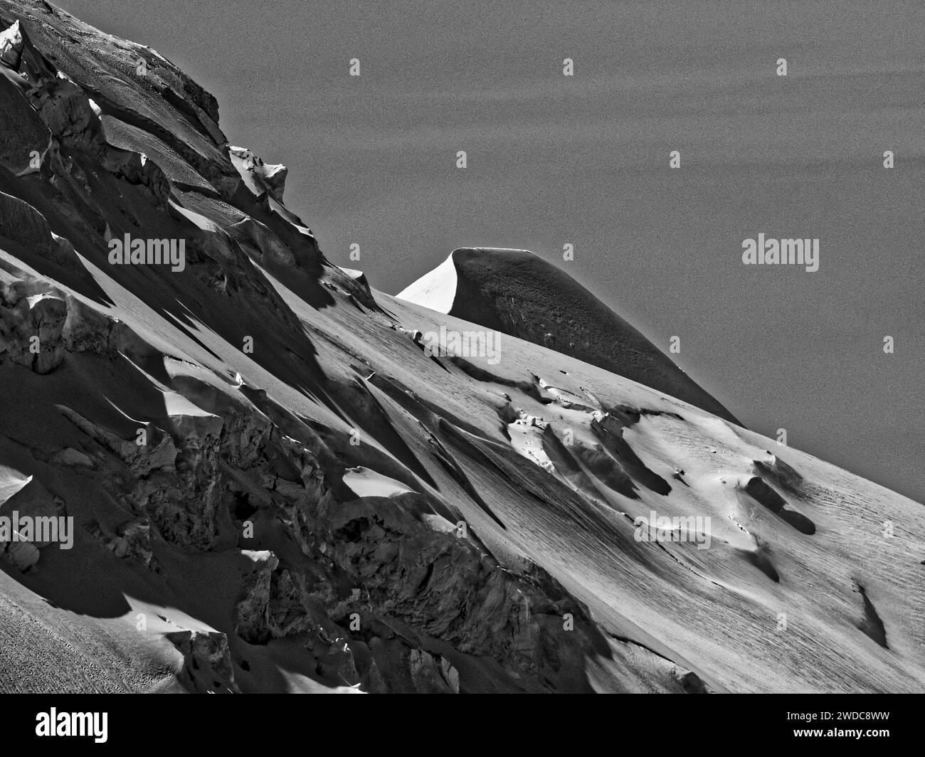 Schwarzweißbild eines schneebedeckten, zerklüfteten Berggipfels mit markanten Kontrasten, Mont Blanc. Chamonix Stockfoto