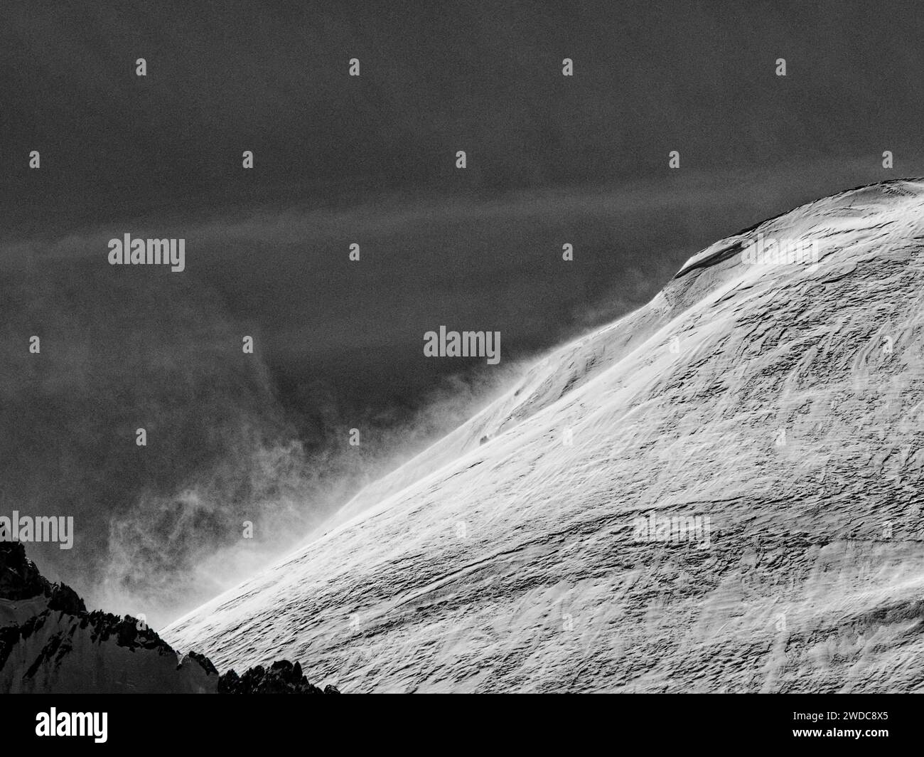 Ein schneebedeckter Berg unter stürmischen Bedingungen, aufgenommen in einem Schwarzweißbild, Mont Blanc. Chamonix Stockfoto