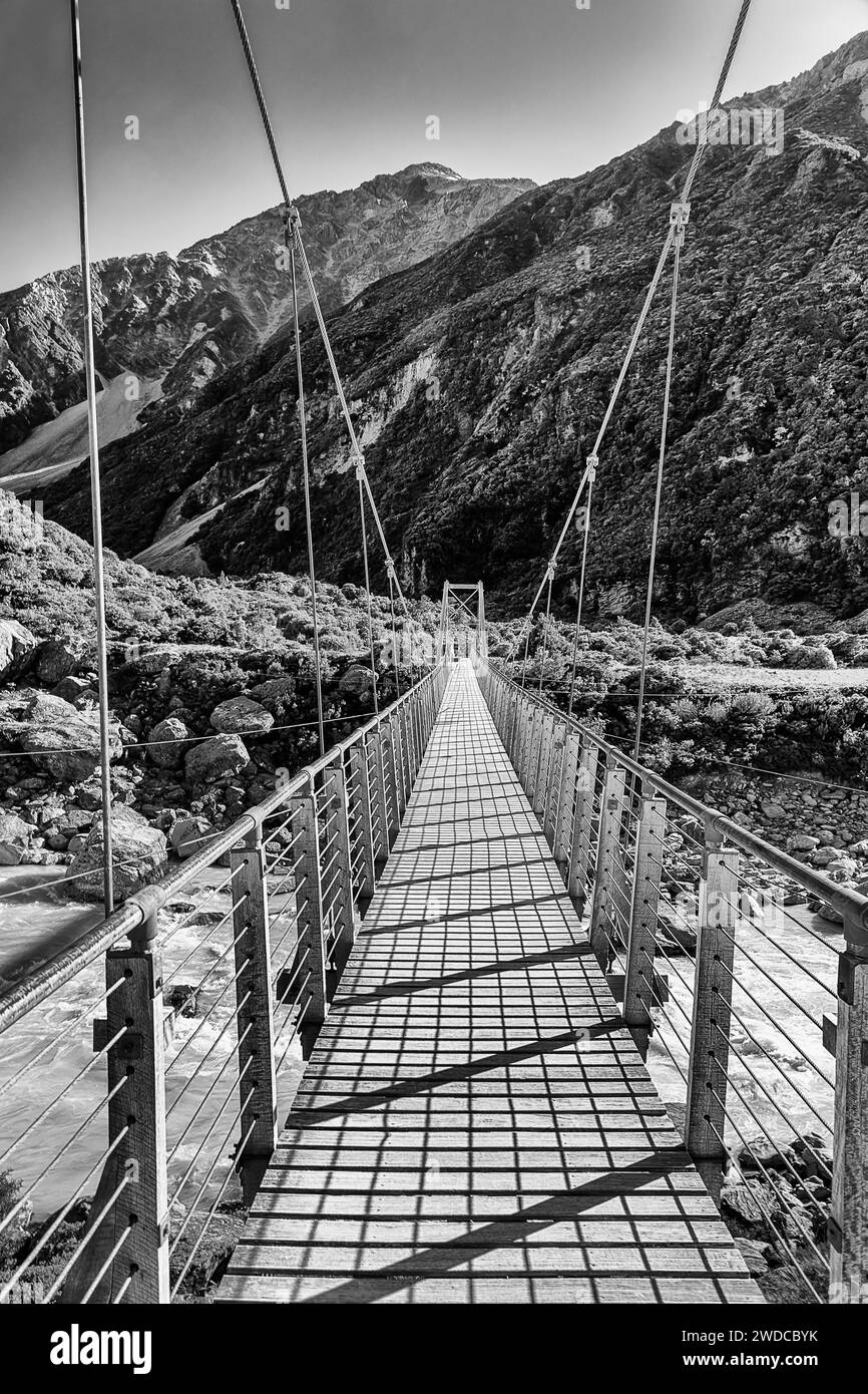 Kontrast BW Hängen Fuß Hängen Hängebrücke über den Hooker River im malerischen Bergtal Neuseelands auf einem Weg zum Mt Cook. Stockfoto