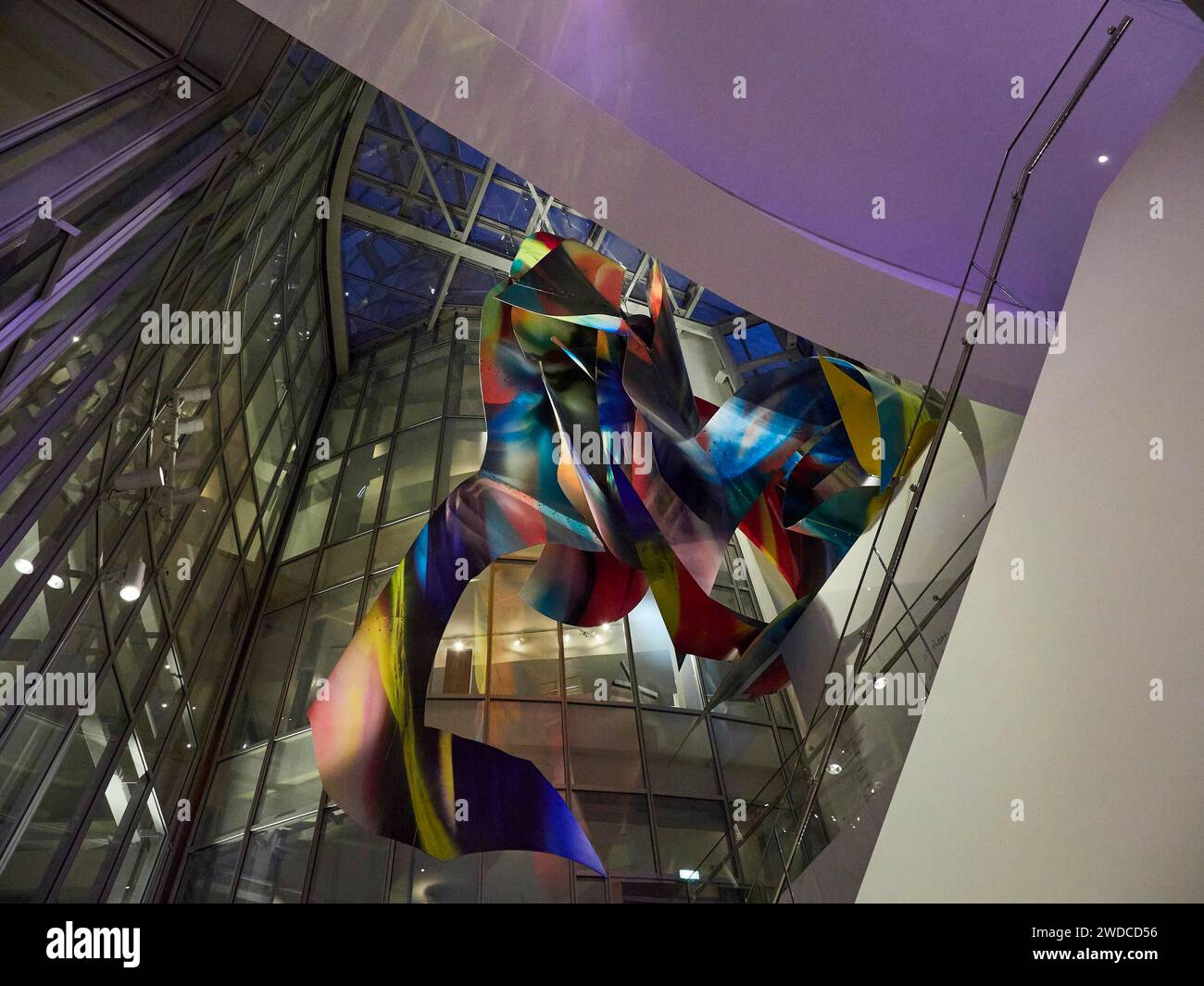 Eine farbenfrohe, abstrakte Skulptur in einem modernen Gebäude mit einer Glasfassade und dynamischer Beleuchtung, Fondation Luis Vuitton. Paris Stockfoto