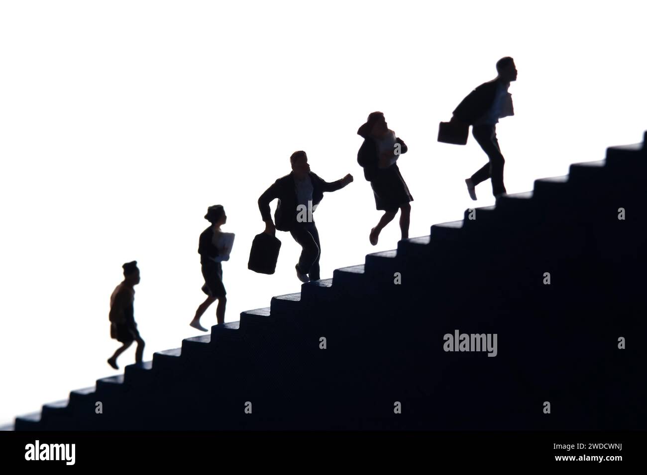 Miniaturmenschen Spielzeug-Fotografie. Die Silhouettengruppe eines Schülers, der auf der Treppe läuft. Isoliert auf weißem Hintergrund. Bild Foto Stockfoto