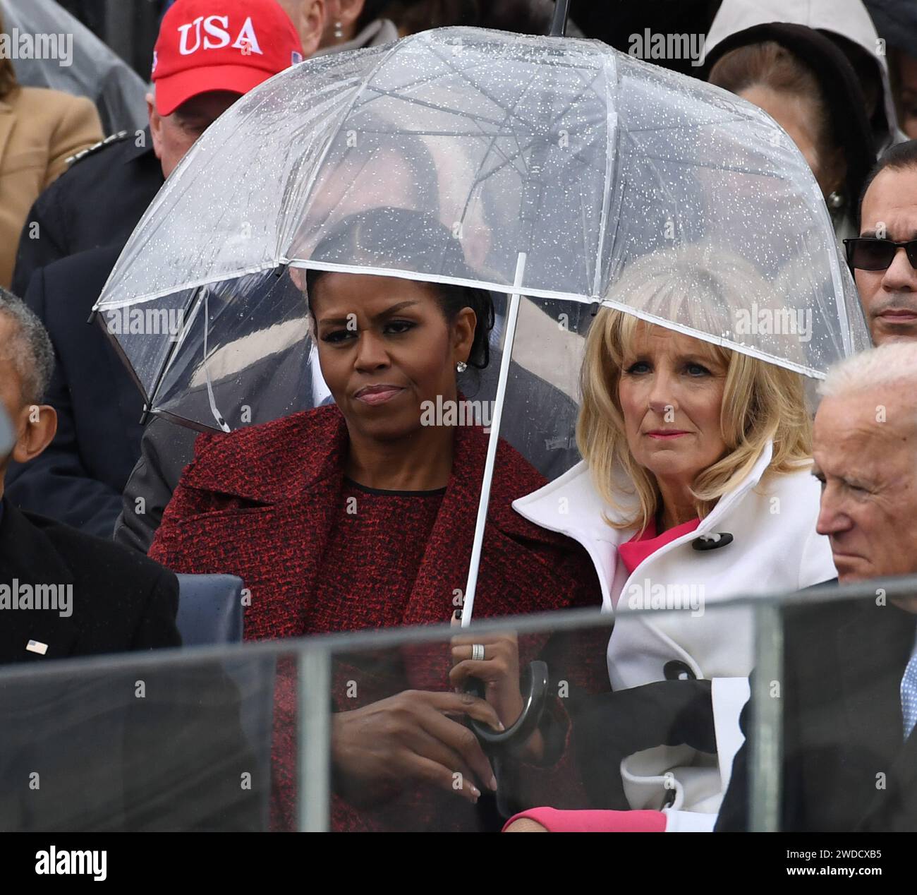 Michelle Obama und Dr. Jill Biden teilen sich einen Schirm, während Präsident Donald Trump seine Antrittsrede bei der Amtseinführung am 20. Januar 2017 in Washington hält. Trump wurde 45. Präsident der Vereinigten Staaten. Foto: Pat Benic/UPI /CNP/MediaPunch Stockfoto