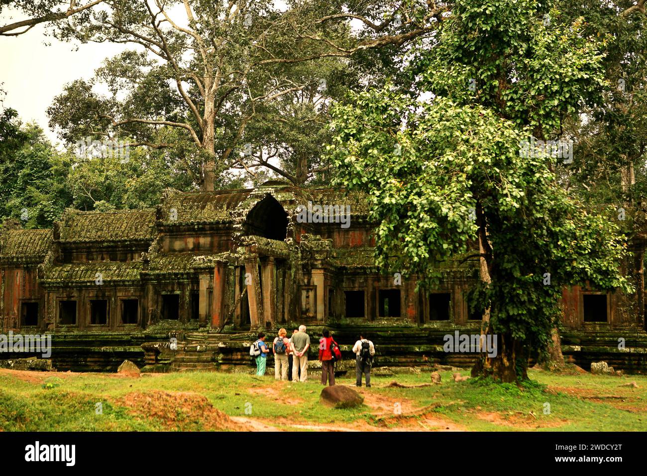 Eine Gruppe internationaler Touristen achtet auf einen ruinierten, nicht identifizierten „Satelliten“-Tempel in der Nähe von Angkor Wat in Siem Reap, Kambodscha. Angkor ist ein erfolgreiches Beispiel für eine langjährige internationale Zusammenarbeit bei der Bewahrung wichtiger Kulturgüter, so die UNESCO in ihrem Bericht vom Juni 2022. Seit der Aufnahme Angkor Wats in die UNESCO-Liste des Weltkulturerbes im Jahr 1992 wurden dreißig Länder und eine Ad-hoc-Expertengruppe für Wissenschafts-, Restaurierungs- und Erhaltungsvorhaben nach einem innovativen Ansatz zusammengeführt, der Schutzmaßnahmen eng mit nachhaltiger... Stockfoto