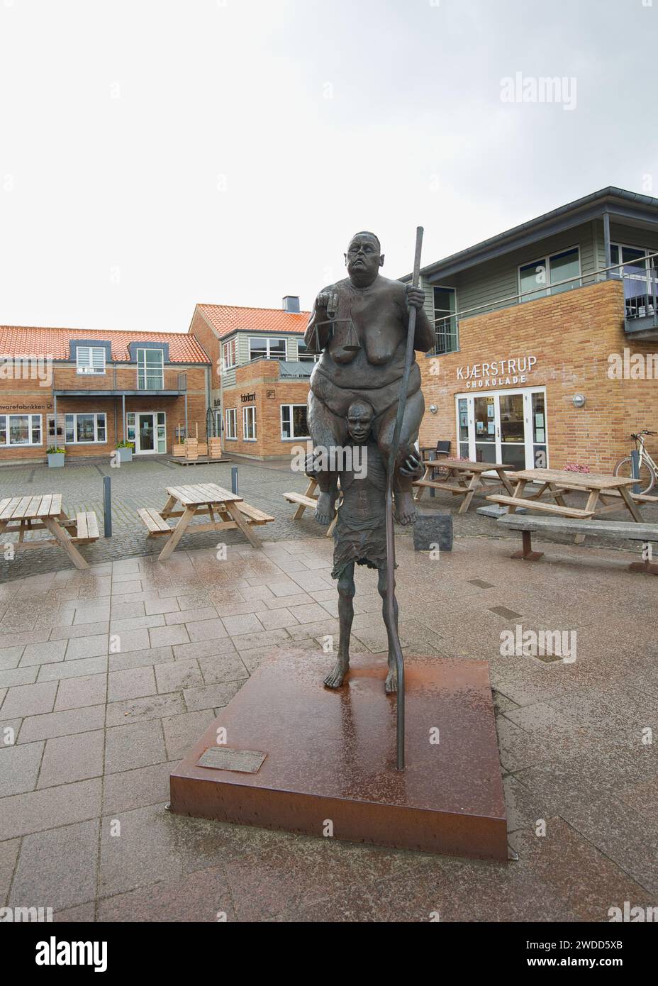 Dänemark, Ringkøbing - 24. Juli 2023: Die Skulptur „Survival of the Fattest“ zeigt eine fette Frau auf den Schultern eines hungernden afrikanischen Jungen. Stockfoto