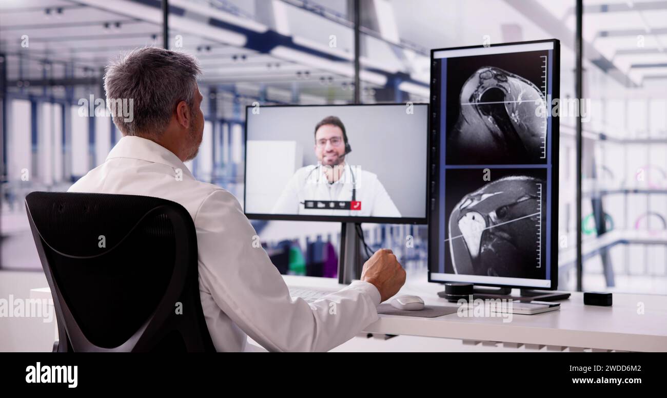 Männlicher Arzt, der mit dem Colleague spricht und sich MRT-Scan ansieht Stockfoto