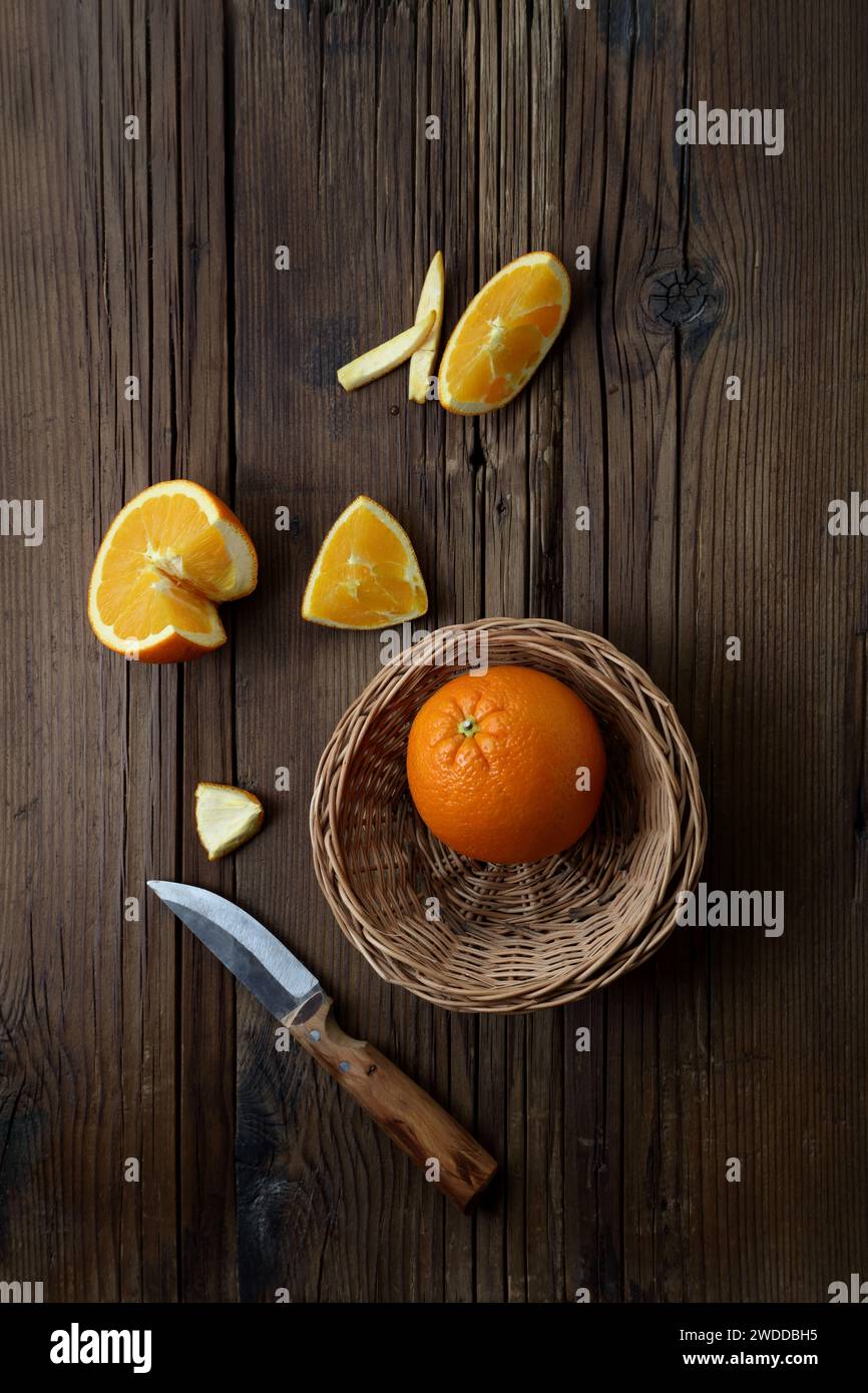 Orange mit Scheiben und Khife auf Holztisch, Obst-Thema Stockfoto