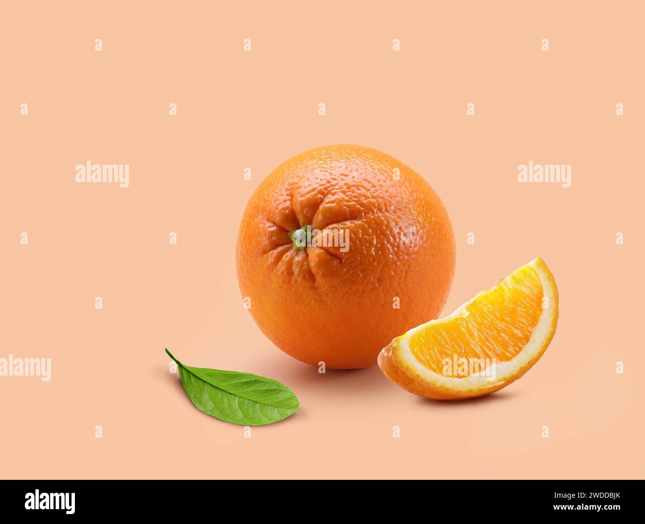 Orange mit Schicht und Blatt auf hellorangem Hintergrund Stockfoto