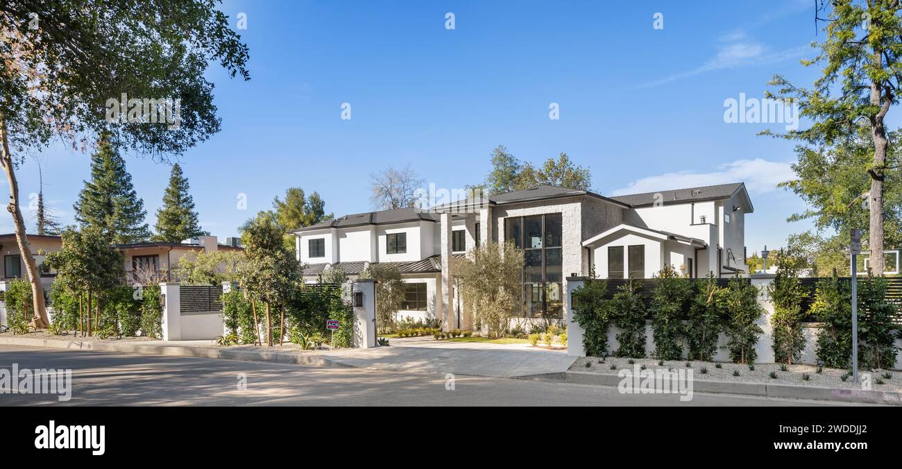 Eine charmante Wohnstraße mit Bäumen und einem Zaun bietet einen Einblick in ein historisches Viertel in Tarzana, Kalifornien Stockfoto