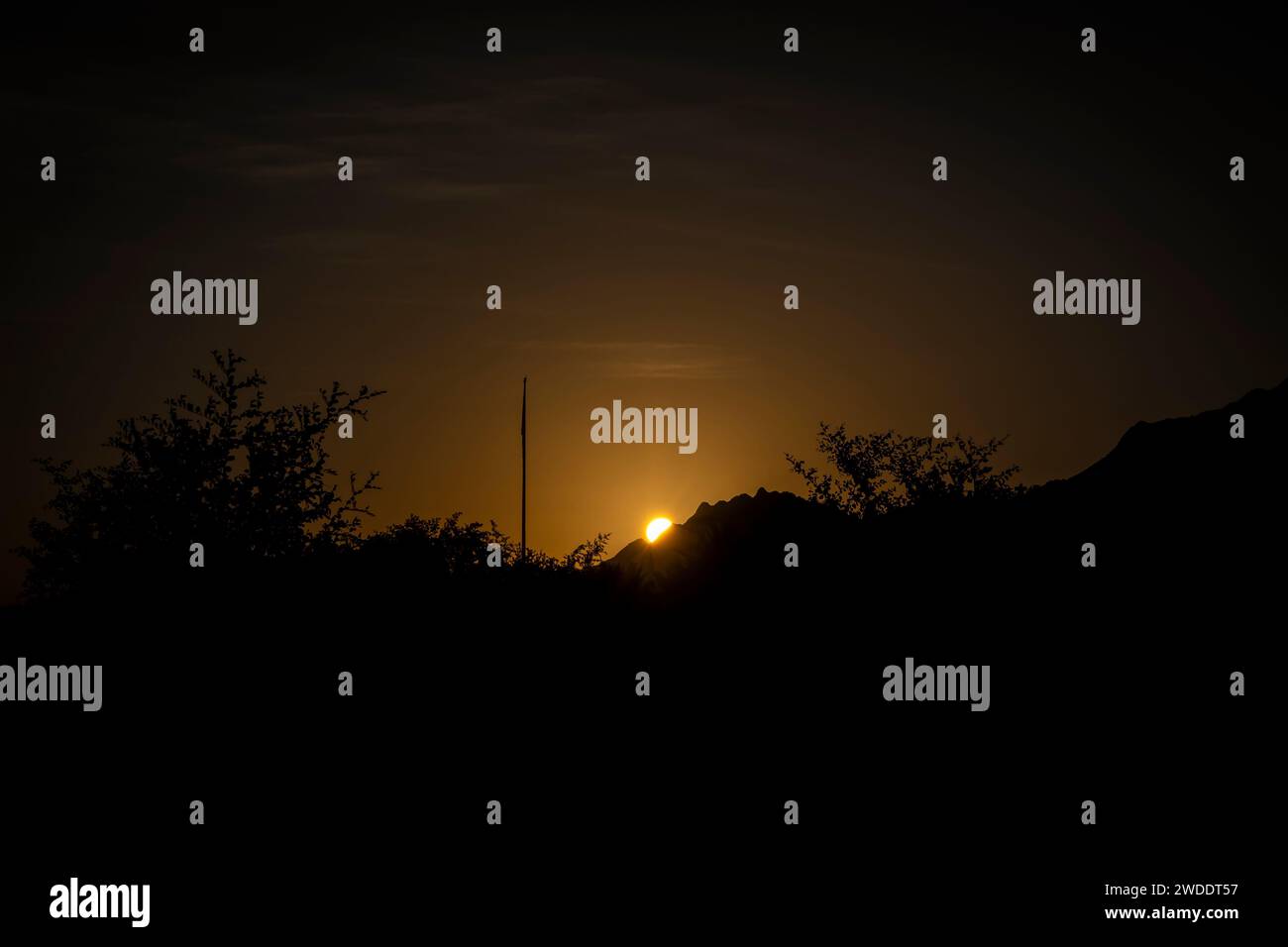 Wunderschöne goldene Stunde Sonnenaufgang hinter den Bergen im Winter in Hatta. Stockfoto