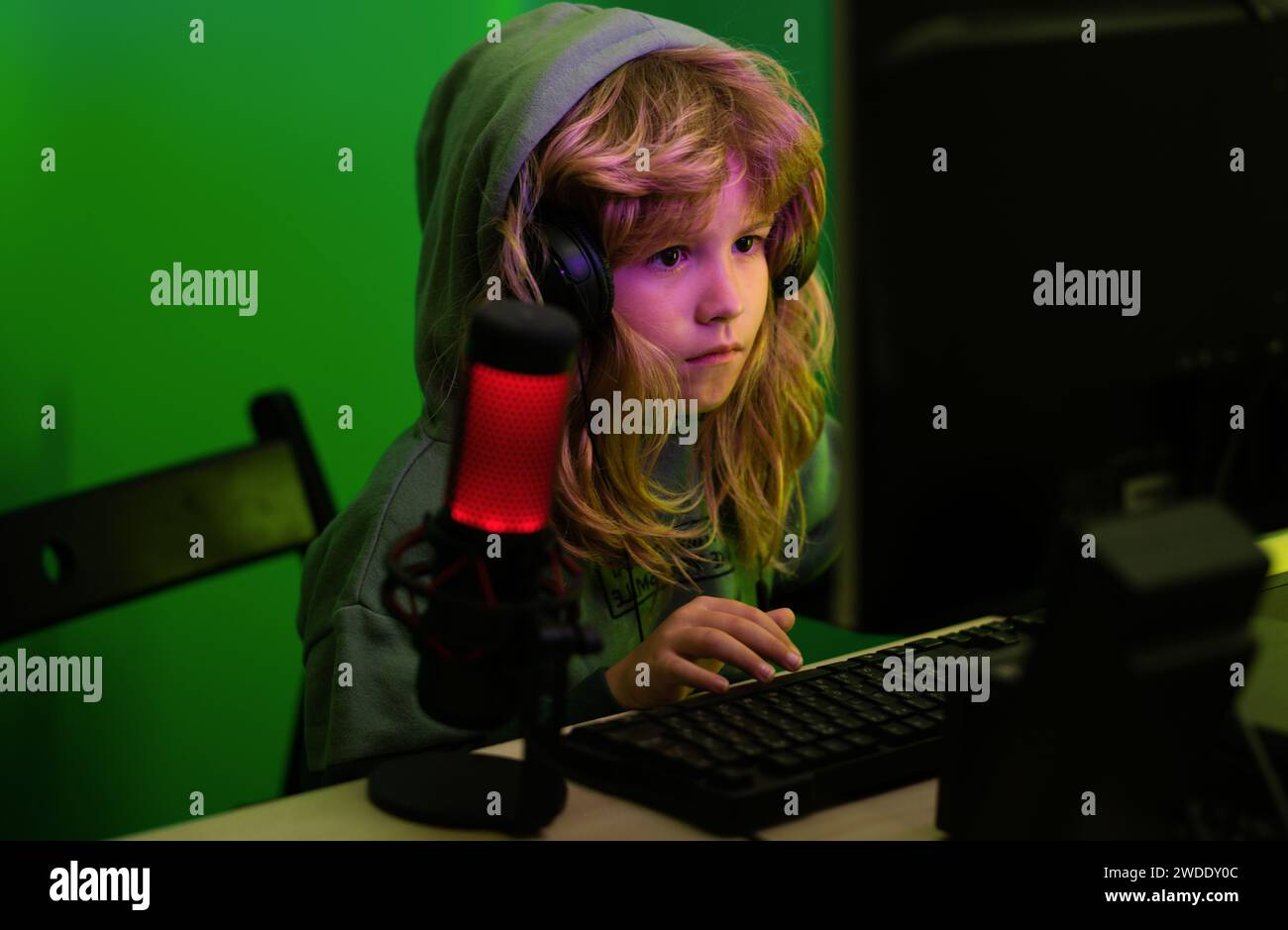 Kind Gamer spielt Videospiel. Kind spielt ein Videospiel auf dem pc-Bildschirm. Gamer spielen Computerspiele. Neonbeleuchtung. Kleiner Hacker, jung Stockfoto