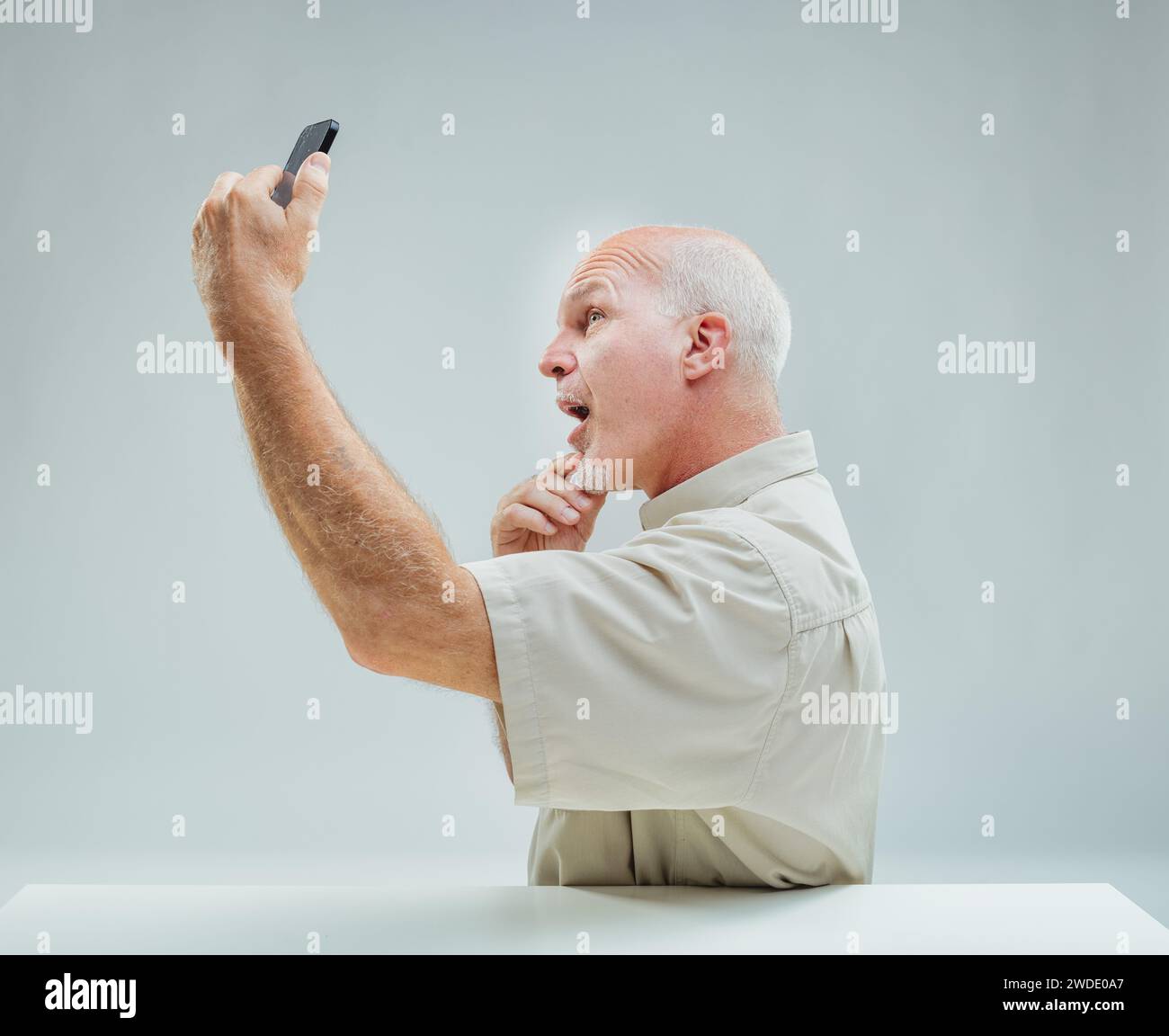 Die animierte Geste des Mannes mit seinem Handy fängt das Wesen einer zärtlichen digitalen Interaktion ein Stockfoto