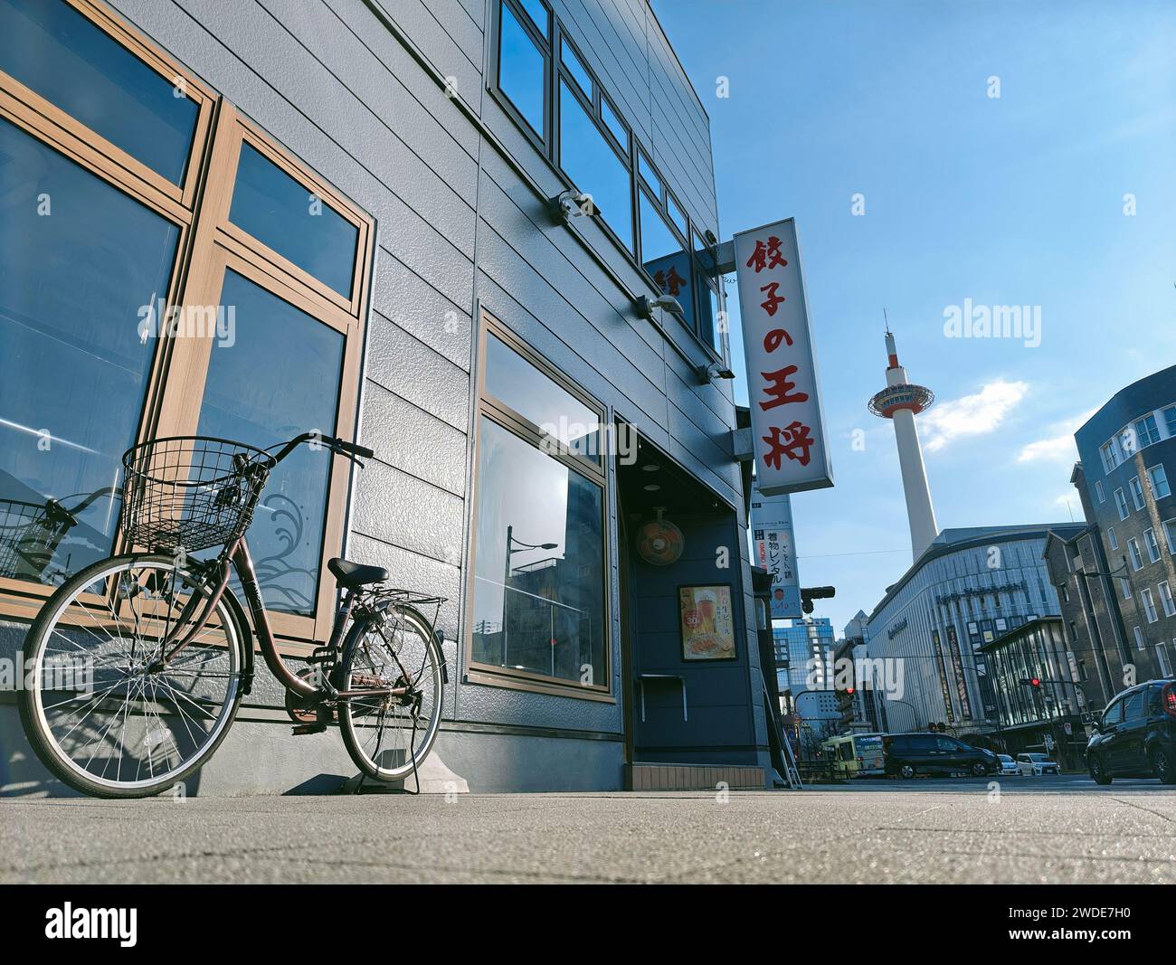 Eine Straßenszene mit einem Fahrrad und dem Kyoto Tower in Kyoto, Japan Stockfoto