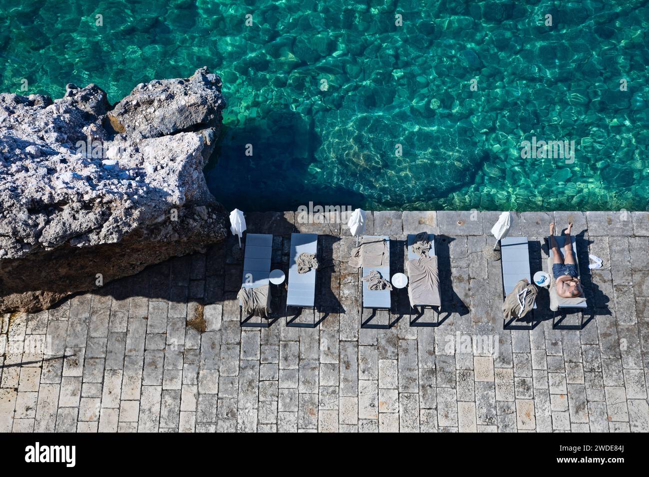 Ein Mann sonnt sich an der Adriaküste in Dubrovnik, Kroatien. Stockfoto