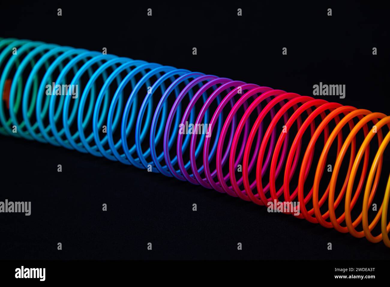 Spirale in vielen bunten Farben vor schwarzem Hintergrund Stockfoto